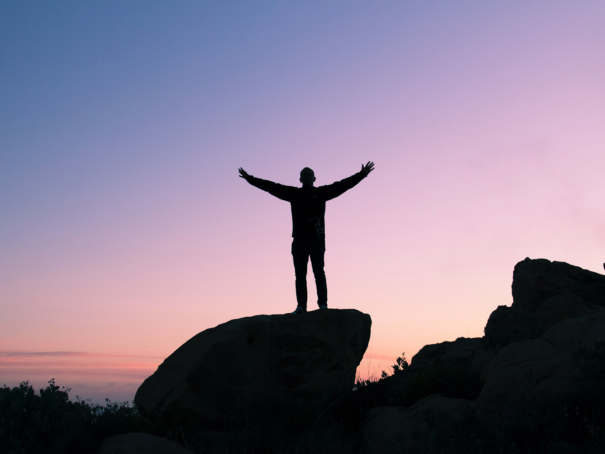 Guy Standing Mountain Achieving Holistic Goals Dreams In Sunset